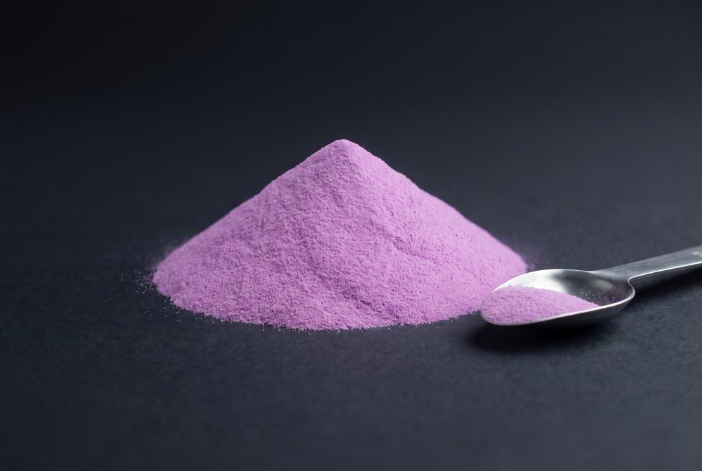 Photoluminescent pigment, violet, as a heap with a scoop, in daylight