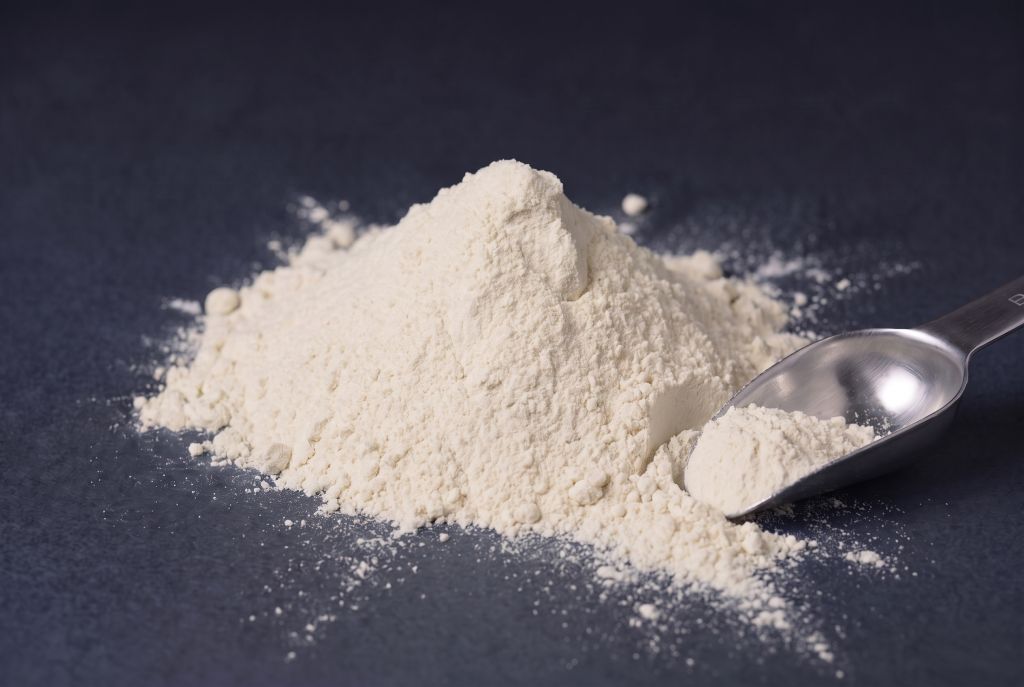 Nachleuchtpigment Natur-Blau als Häufchen mit Messlöffel bei Tageslicht
