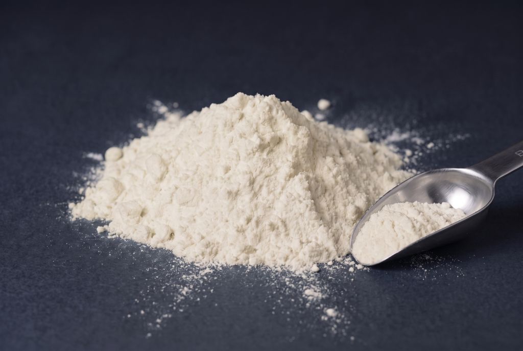 Nachleuchtpigment Natur-Gelb als Häufchen mit Messlöffel bei Tageslicht