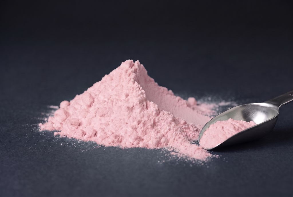 Nachleuchtpigment Pink-Oceanpink als Häufchen mit Messlöffel bei Tageslicht