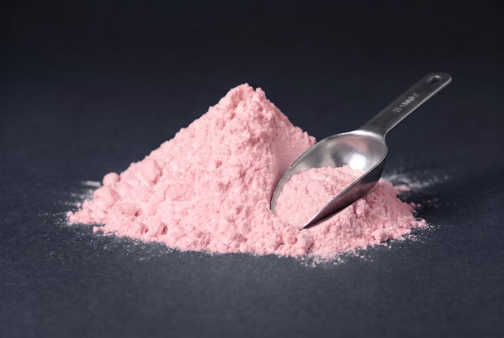 Nachleuchtpigment Pink-Pink als Häufchen mit Messlöffel bei Tageslicht